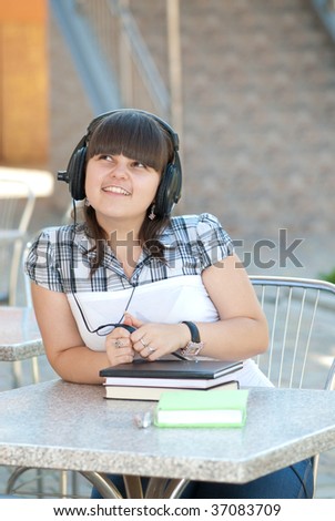 Young student listening to music with big headphones