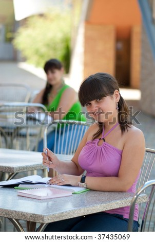 Two young students studying in campus cafe