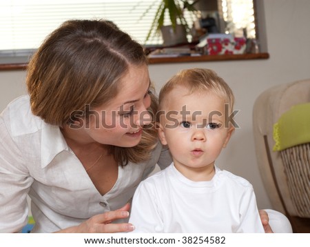 Young mother is whispering a secret to her son