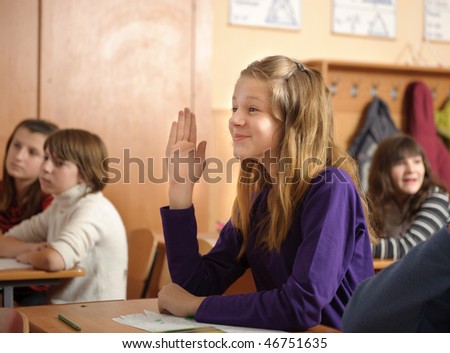 Funny schoolgirl is raising up her hand