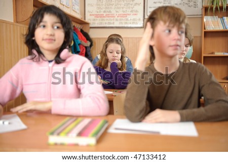 School life routine. Bored girl on second desk is in primary focus. Shallow depth of field.