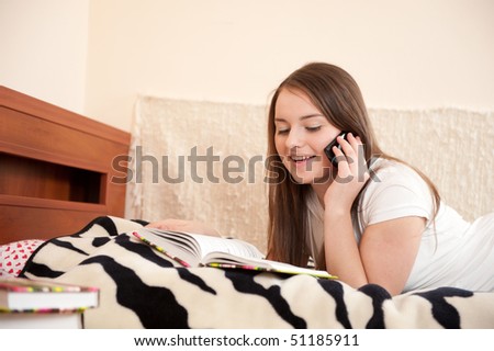 Young female student is talking via phone during study