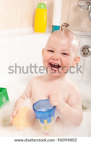 Little baby girl having soapy bath at home