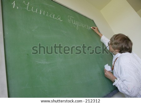 The teacher writes on a board.