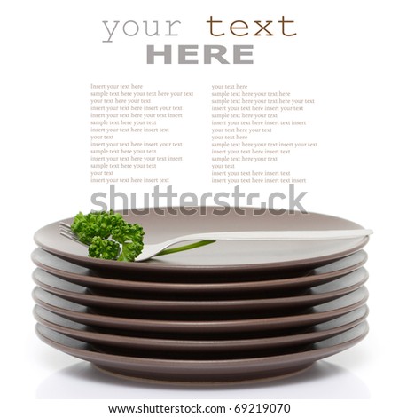 Stack of brown round plates with fork and parsley (with sample text)