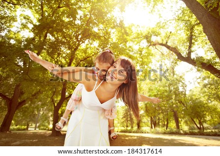 Playful mother and little daughter enjoying in nature.