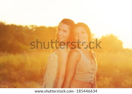 Two beautiful women portrait on a summer sunset. Toned image.