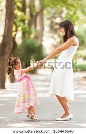Mother and little daughter having fun in a park on a nice sunny day.
