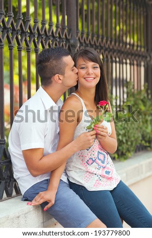 Young man giving red rose to his girlfriend