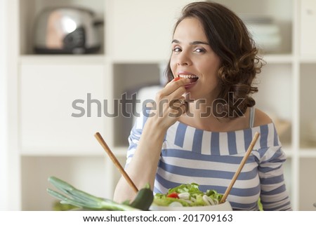 Young smiling woman eat vegetables