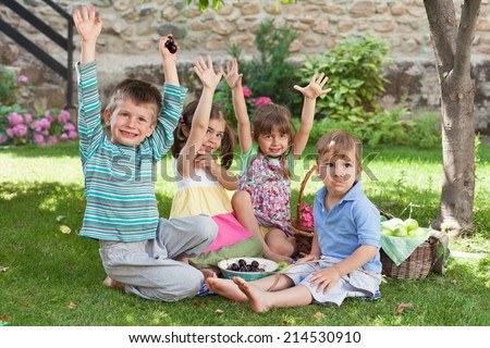 Group of happy children having a picnic in a backyard