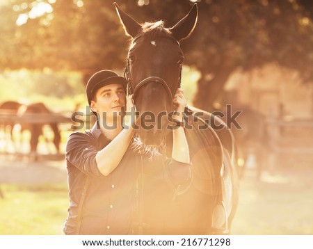 Young jockey preparing his horse for a ride