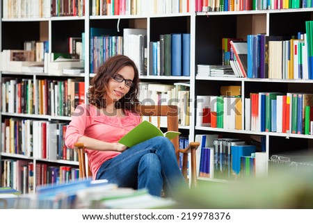 Beautiful young woman enjoying a good book in the library.