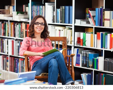 Beautiful young woman enjoying a good book in the library.