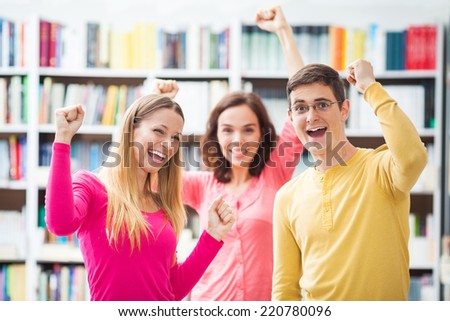 Group of excited adult students in the library.