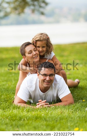 Portrait of happy family making a human pyramid in the meadow.