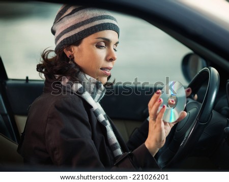 Woman driving and listening music on the cd player