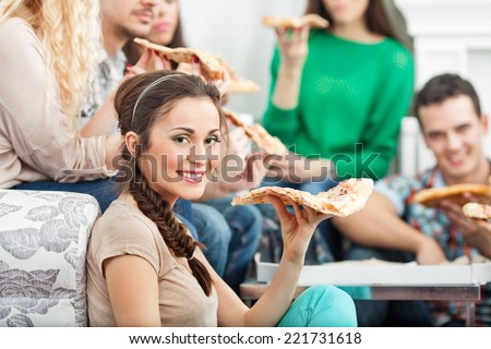 Young friends eating pizza in an apartment