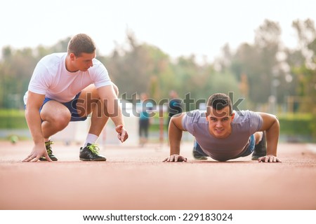 Young man exercising with personal trainer