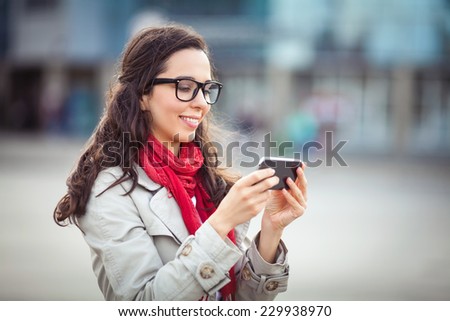 Beautiful young woman on the street using smart phone.