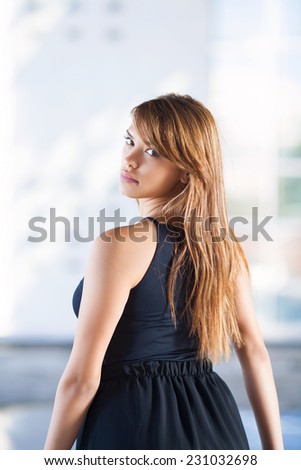 Rear view of beautiful young woman with long hair wearing black