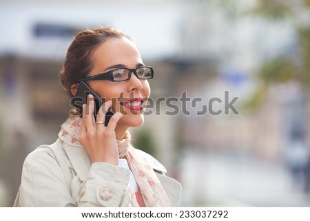 Young woman talking on the phone on the street
