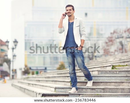 Young man walking down the stairs talking on the phone