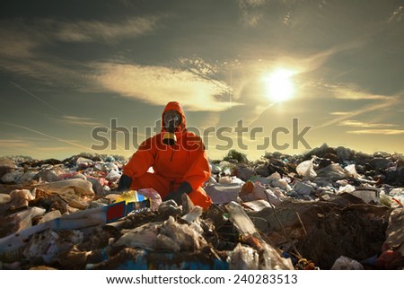 Portrait of recycling worker among garbage bags on the landfill