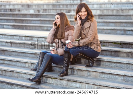 Two young women on the phones during the coffee break