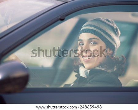 Happy young woman driving a car