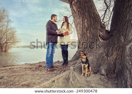 Young couple exchanging presents for Valentine\'s Day in nature