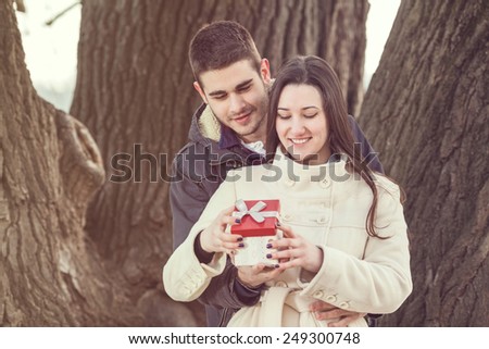 Young couple opening gift in nature