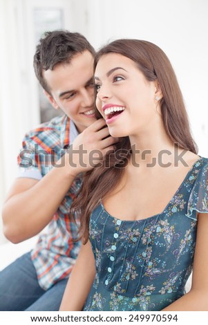 Young man whispering to his girlfriend