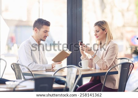 Two young business people on a coffee break in a restaurant.