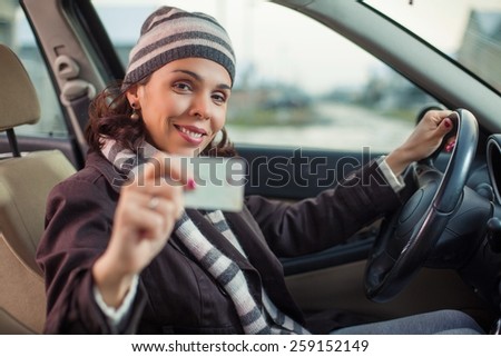 Happy young woman showing her driver\'s license