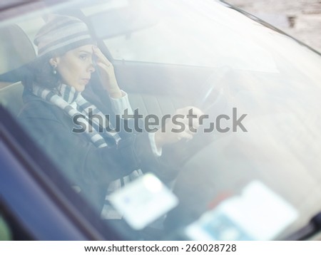 Looking through car window at frustrated woman behind the steering wheel