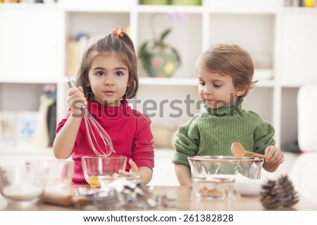 Children playing in the kitchen and learning how to bake