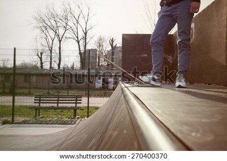 Close-up of skater\'s leg on a skateboard while preparing for a jump on a skate ramp