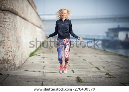 Young woman exercising outdoors with jump rope