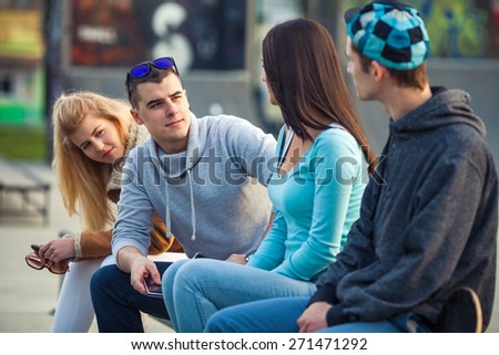 Group of four young people hanging out outdoors