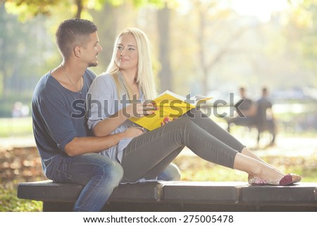 Two university students sitting in a park studying