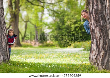 Happy family hiding behind trees while playing in a park