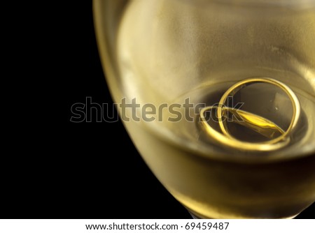 stock photo Glass of white wine with wedding rings inside