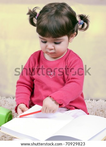Adorable little girl reading and writing