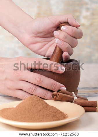 Hands ground spices in mortar