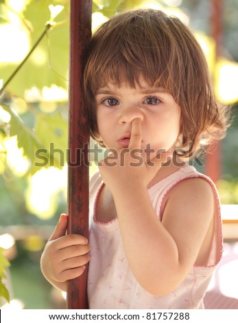 Cute little toddler girl picking her nose