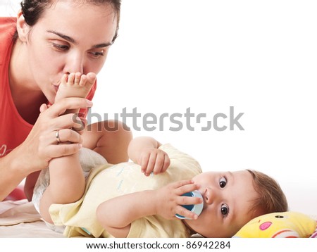 stock photo Young mother kissing tiny feet of her cute baby boy