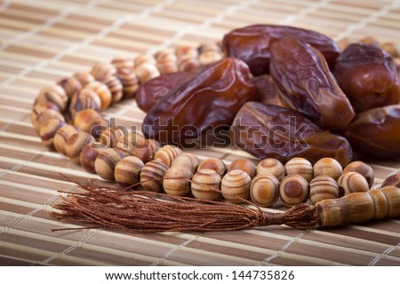 Dates and muslim prayer beads on matting