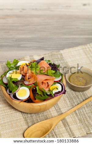 Smoked salmon salad with red onion, egg, carrots and radishes