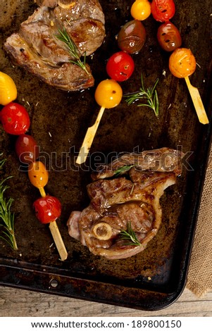 Roasted Lamb Chops with cherry tomato and rosemary. Selective focus.